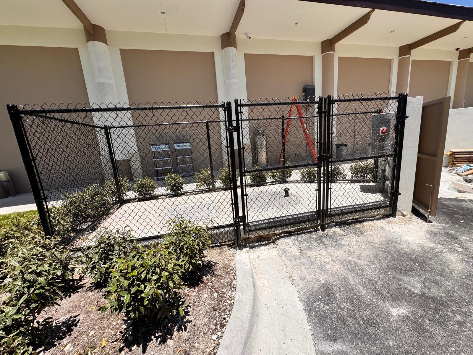 Black chain link enclosure with gate