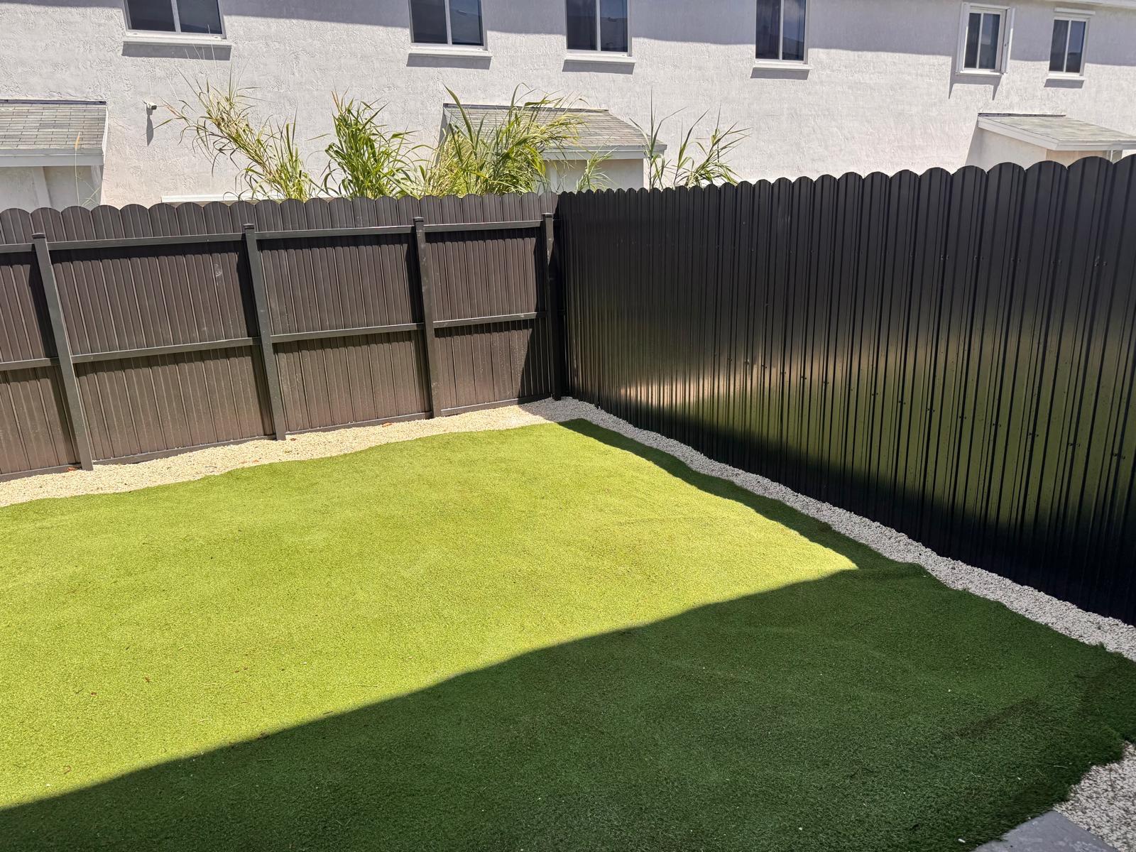 Black metal fence with artificial turf backyard