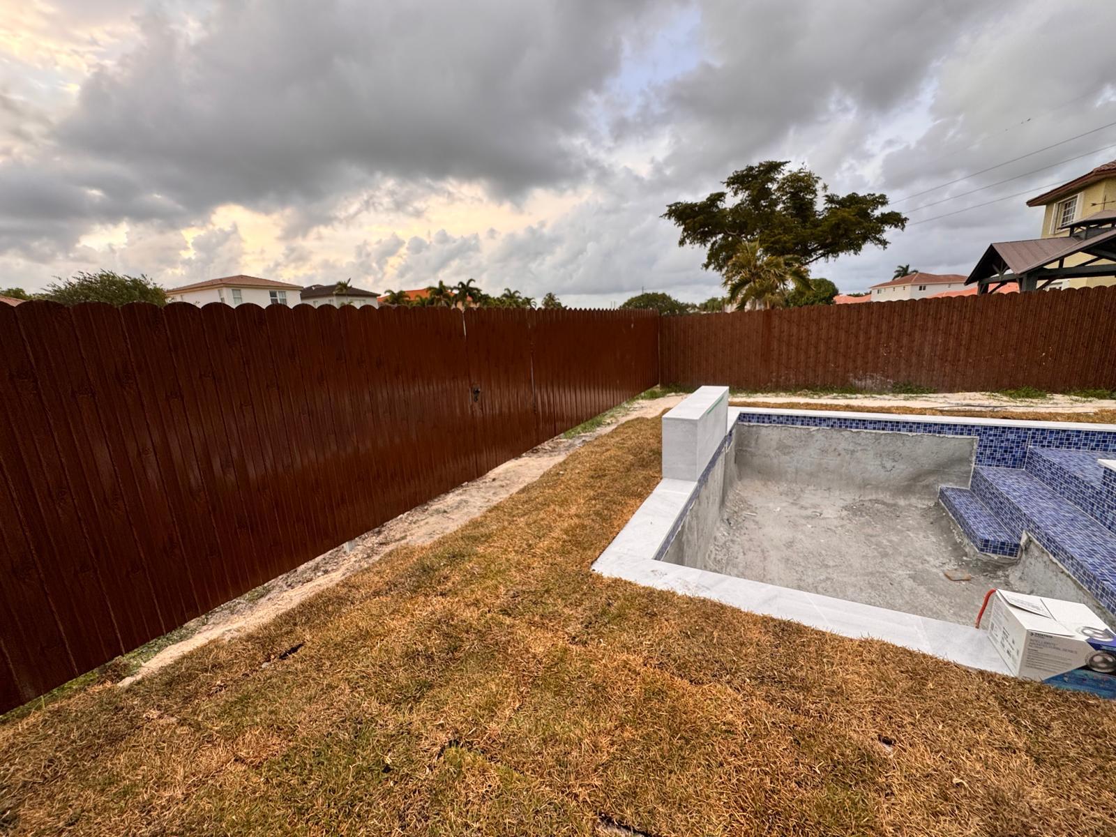 Stained wood privacy fence around new pool
